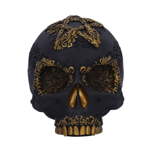 A decorative black skull features intricate gold floral patterns around the eyes and top, with gold accents on the teeth and nose, creating an ornate and gothic appearance.