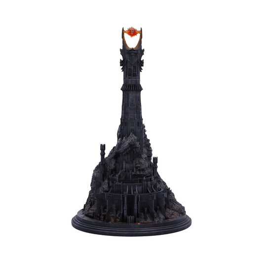 A dark, intricate tower model features an ominous orange eye at its peak, set against a plain white background. The base is detailed with rocky textures and fortress-like structures.