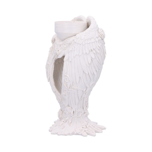 A white, sculpted candleholder, shaped like angel wings, holds a small candle. It is ornately detailed with floral accents. The object sits on a white background.