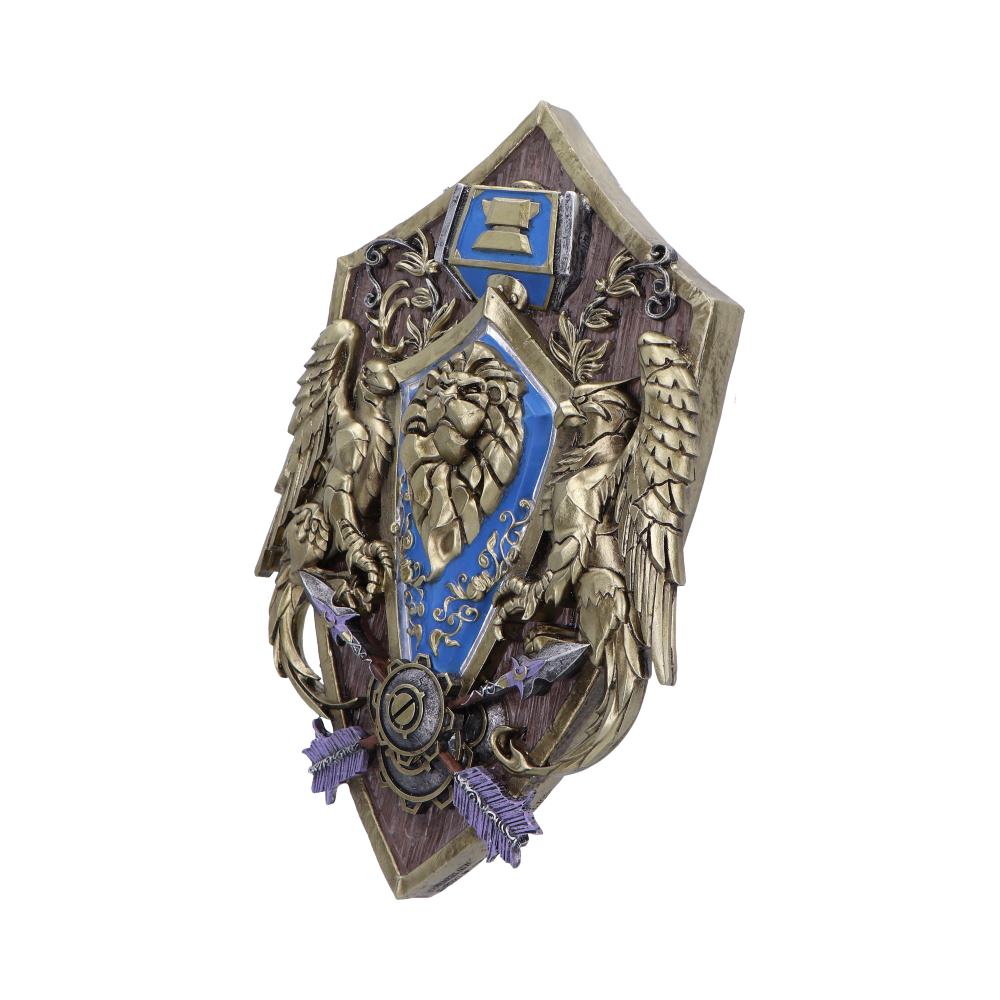 A decorative shield features a lion emblem, entwined with ornate patterns and flanked by winged creatures, mounted on a wooden plaque and crossed with purple arrows, against a plain background.