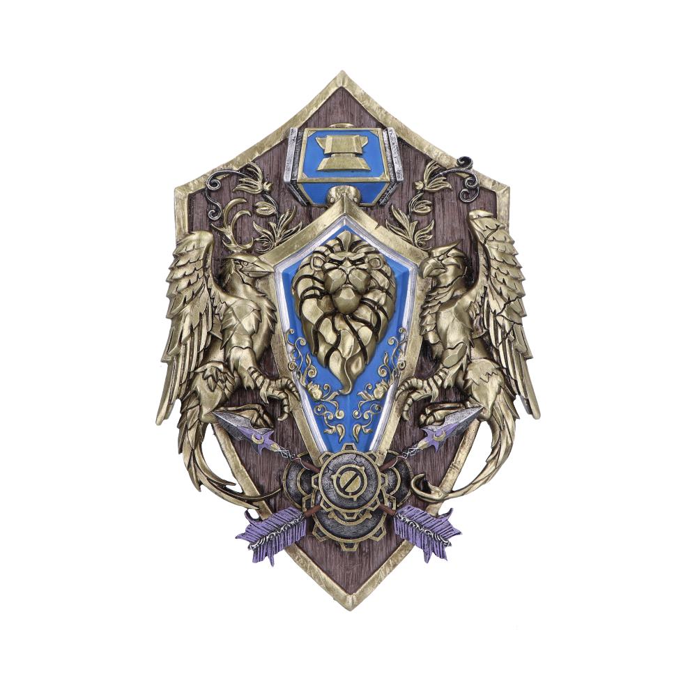 An ornate shield features a lion emblem at its center, flanked by two winged creatures, decorated with a blue banner and arrows against a wooden backdrop.