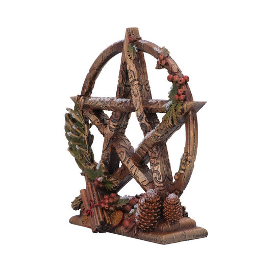 A pentagram stands on a base; it is made of wood, decorated with winter greenery, and dusted with snow.