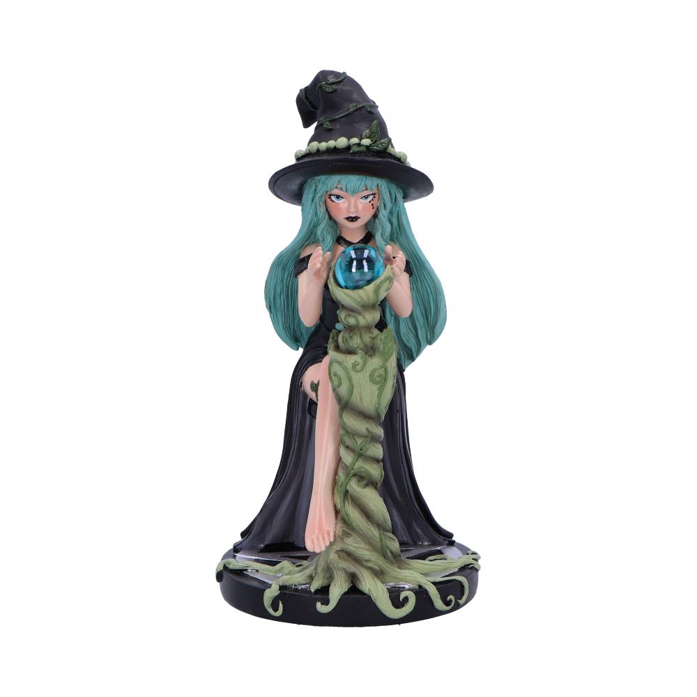 A witch figurine gazes into a crystal ball atop a vine-like column; she is seated, barefoot, in a long black dress against a white background.