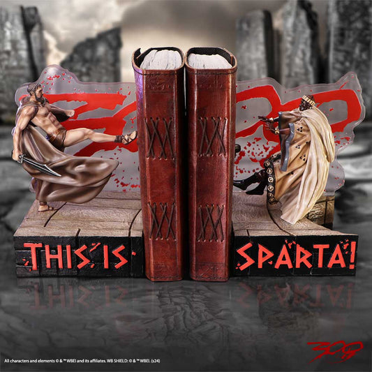 Bookends depict a warrior kicking another figure with a sword in hand. Set against a dramatic backdrop, two books stand upright. Text reads: "THIS IS SPARTA!" Red slashes accentuate the scene.