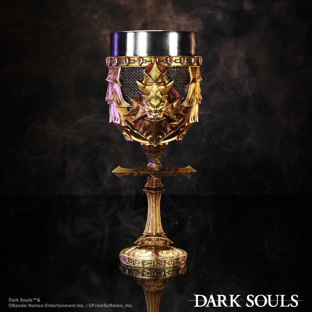 A golden goblet with ornate designs and a metallic rim stands upright. Smoke swirls around it against a dark background. Text: "DARK SOULS," "Dark Souls™ © Bandai Namco Entertainment Inc. / © FromSoftware, Inc."