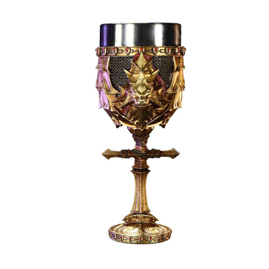 An ornate goblet features a gold base adorned with a dragon motif, highlighted by deep red accents, and a metal rim, set against a plain white background.