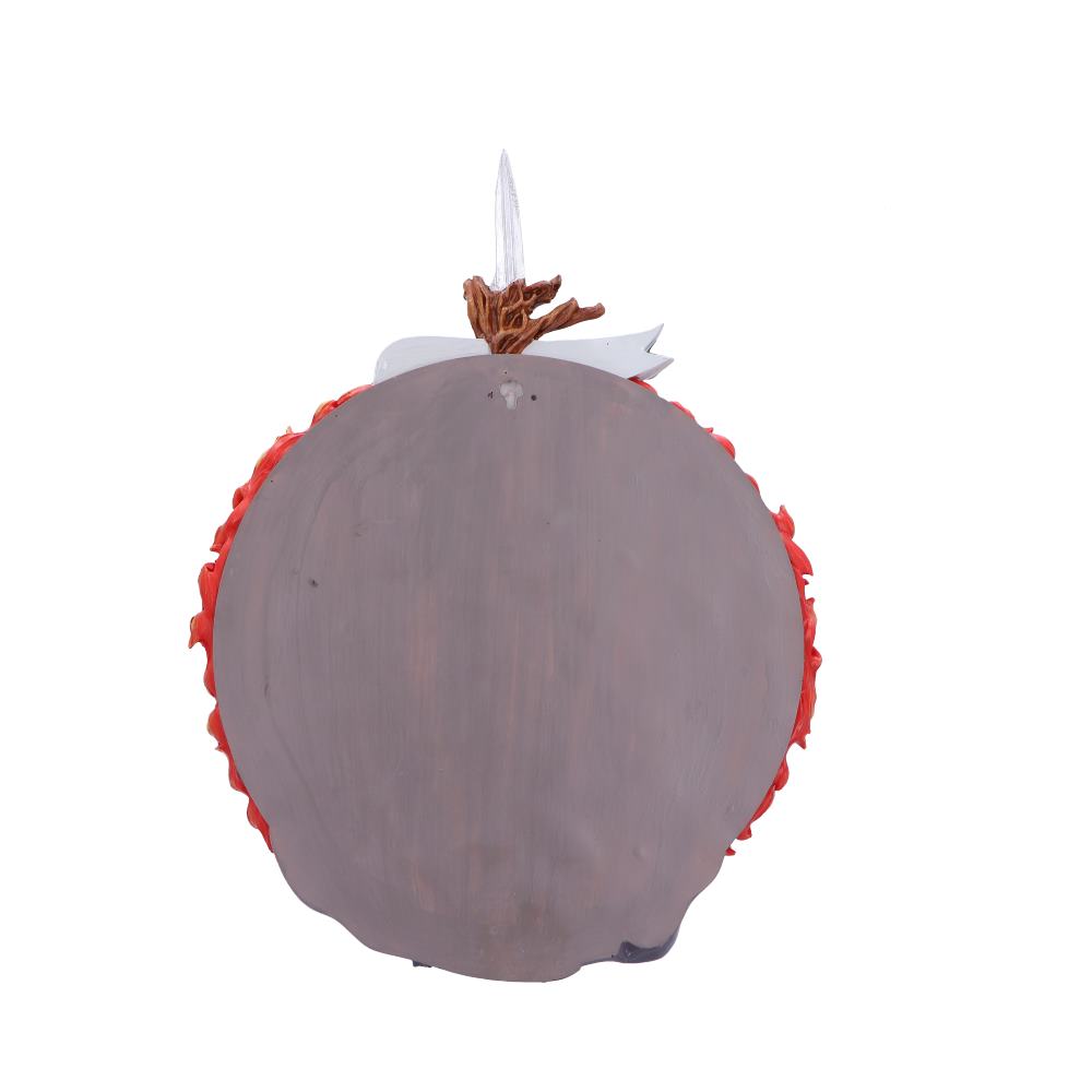 A large, round, wooden shield with a rough, painted surface has red edges and a central metallic element resembling a spear. The background is plain white.
