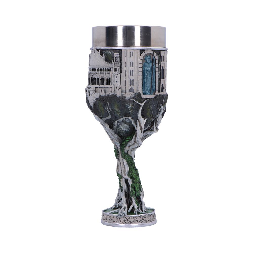A decorative chalice features intricate castle and tree designs wrapped around the cup, with a metallic rim and textured base, set against a plain white background.