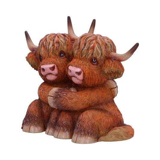 Two sculpted Highland cows, with detailed shaggy fur and large horns, are embracing each other affectionately. Their expression is gentle, set against a plain white background.
