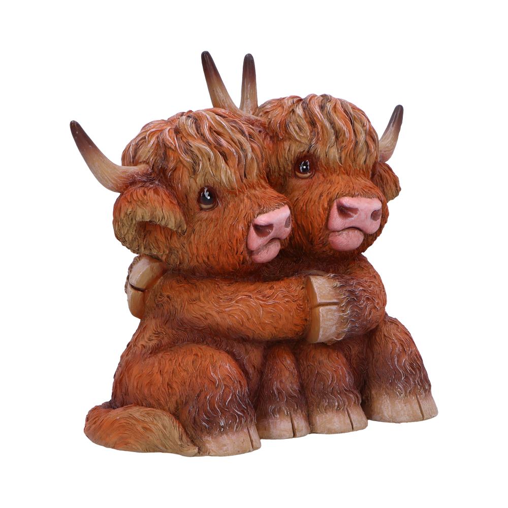 Two adorable, cartoon-style highland cows hug each other affectionately. They have shaggy fur, large eyes, and curved horns. The scene is set against a plain white background.