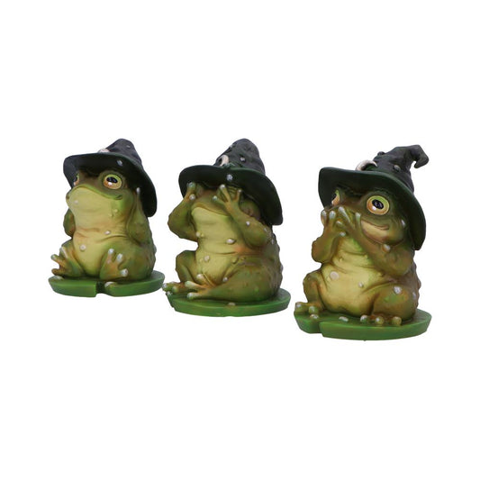 Three frog figurines wear witch hats, each adopting a different gesture (see no evil, hear no evil, speak no evil) against a plain white background.