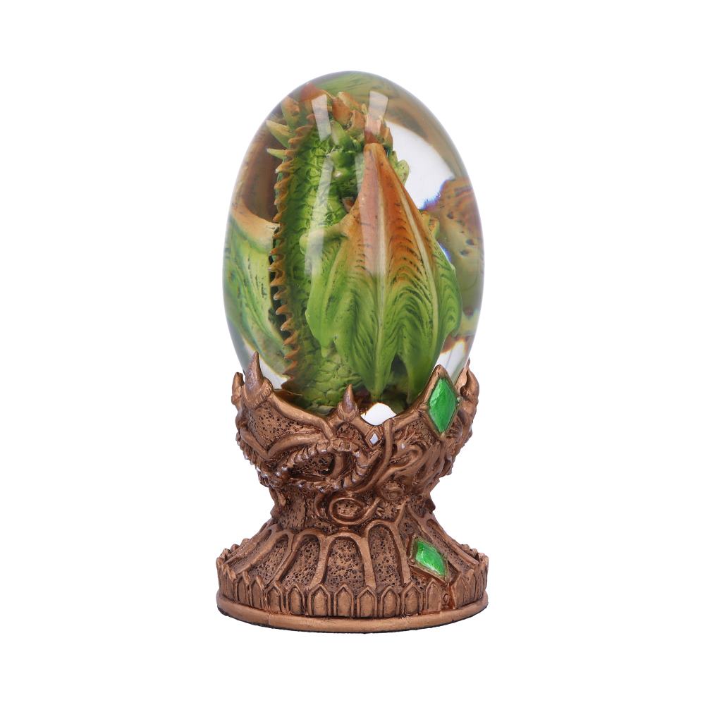 A green dragon sculpture encased in a clear, egg-shaped resin sits on an ornate, bronze-colored base adorned with green gems, isolated against a plain background.
