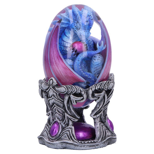 A blue dragon encased in a purple and pink translucent egg holds a pink sphere, supported by an ornate silver stand with leaf designs and purple gemstones.