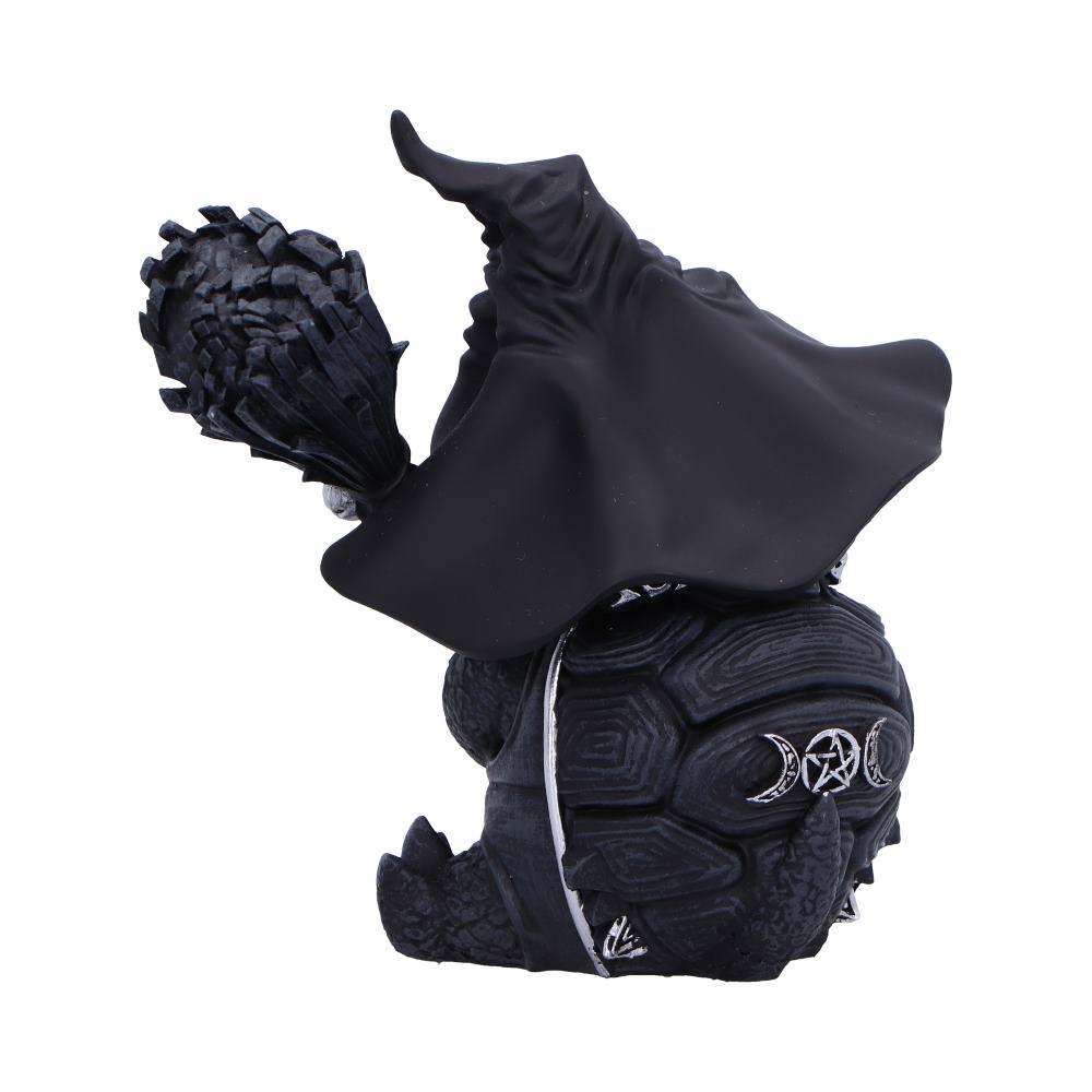 A black tortoise figurine, wearing a wizard's hat and cloak, holds a crystal-topped staff. The tortoise's shell features crescent moons and a pentacle symbol. The backdrop is plain white.