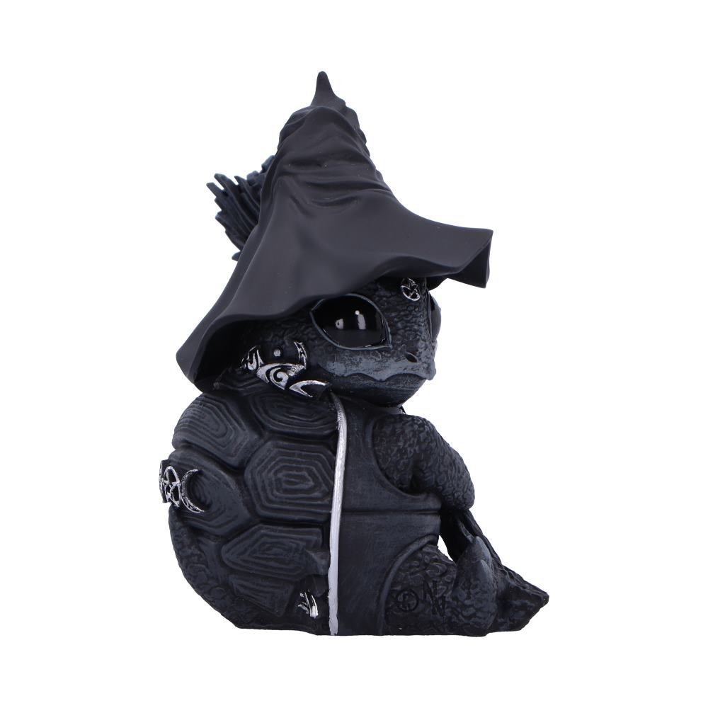 A turtle figurine wearing a black wizard hat sits with intricate designs on its shell and body. The setting is a plain white background, highlighting the figurine's details.