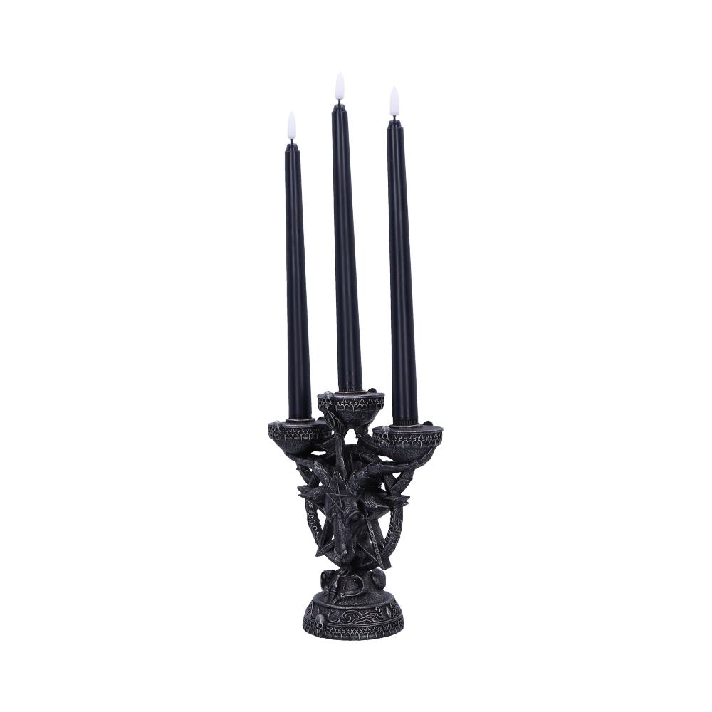 A black, ornate candelabra holds three unlit black candles with white tips, featuring a gothic, star-themed design, set against a plain white background.