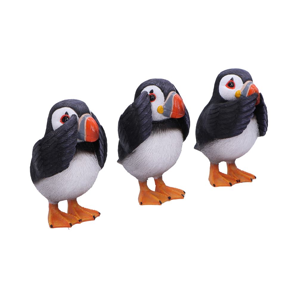Three puffin figurines display a "see no evil, hear no evil, speak no evil" pose. Each bird covers eyes, ears, or beak with wings. They stand on an isolated white background.
