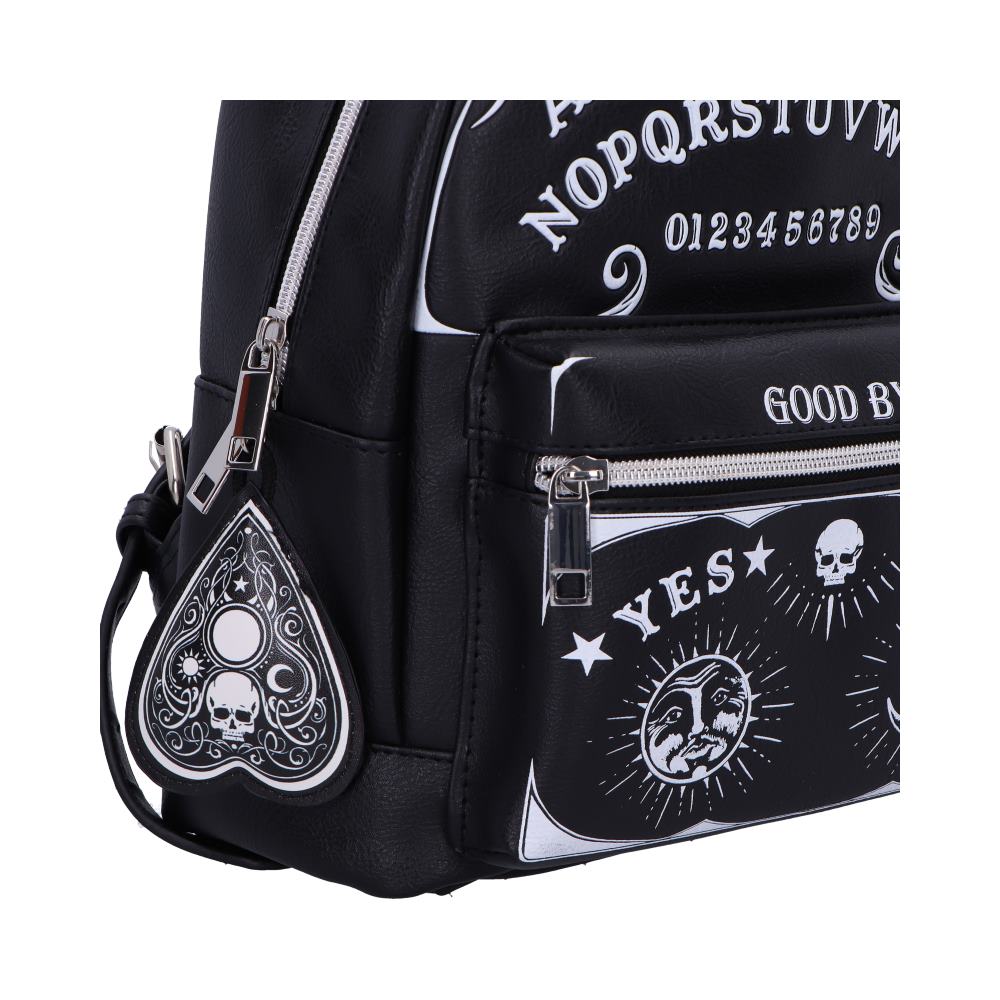 Black mini backpack displays occult themed prints and a planchette keychain showing letters NOPQRSTUV, numbers 0123456789, the words GOOD BY and YES against a white background.