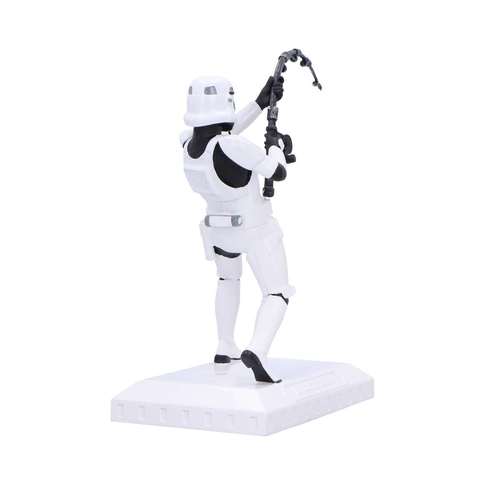 Stormtrooper action figure raises a hooked grapnel above its head with both hands while standing on a white rectangular display base against a plain white background.