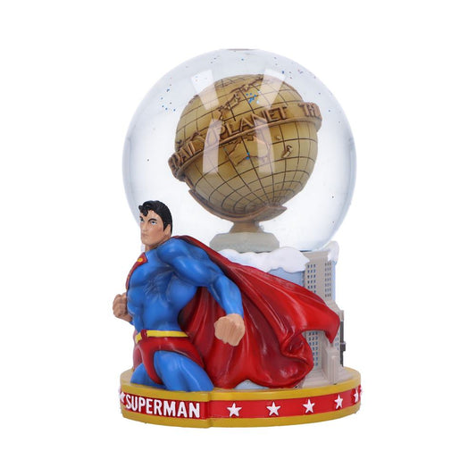 Superman figurine kneels with fist clenched and red cape billowing before a snow globe containing a golden globe labeled DAILY PLANET atop a cityscape base labeled SUPERMAN