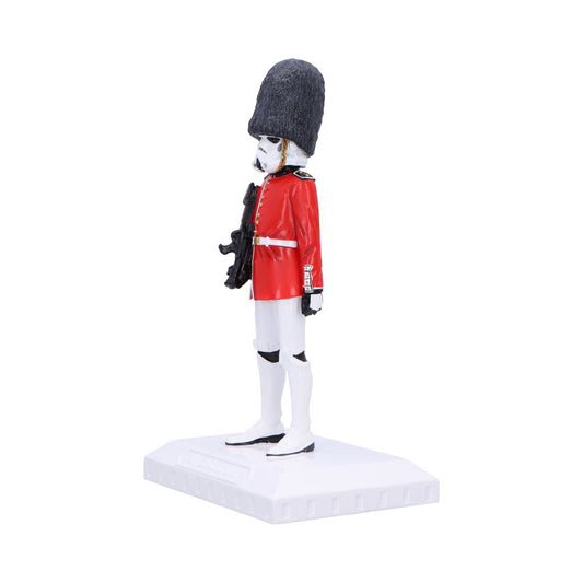 Toy figurine of a white stormtrooper wearing a red British guard tunic and tall bearskin hat stands at attention holding a rifle on a white rectangular display base.