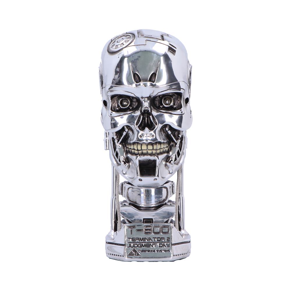 Chrome T-800 robotic skull sits facing forward on a pedestal, exposing mechanical teeth and eye sockets against a plain white background; base reads 'T-800 TERMINATOR 2 JUDGMENT DAY CYBERDYNE SYSTEMS'.