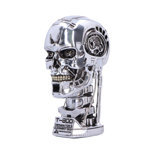 Chrome T-800 endoskeleton skull angled three-quarter left on a display base against a white background, revealing mechanical jaws, gears, and cables; text on base: T-800 TERMINATOR 2 JUDGMENT DAY CYBERDYNE SYSTEMS