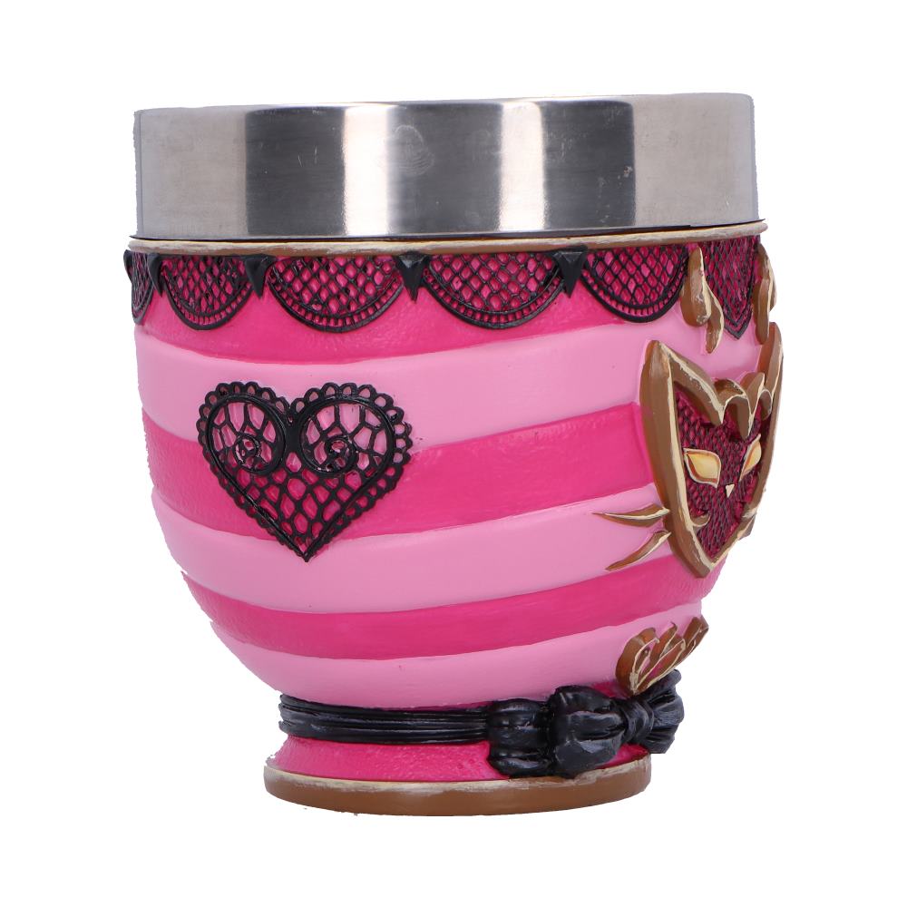 A small pink and magenta striped decorative cup sits upright, featuring a silver metal rim, black lace heart motifs and a gold fox-mask emblem, photographed against a plain white background.