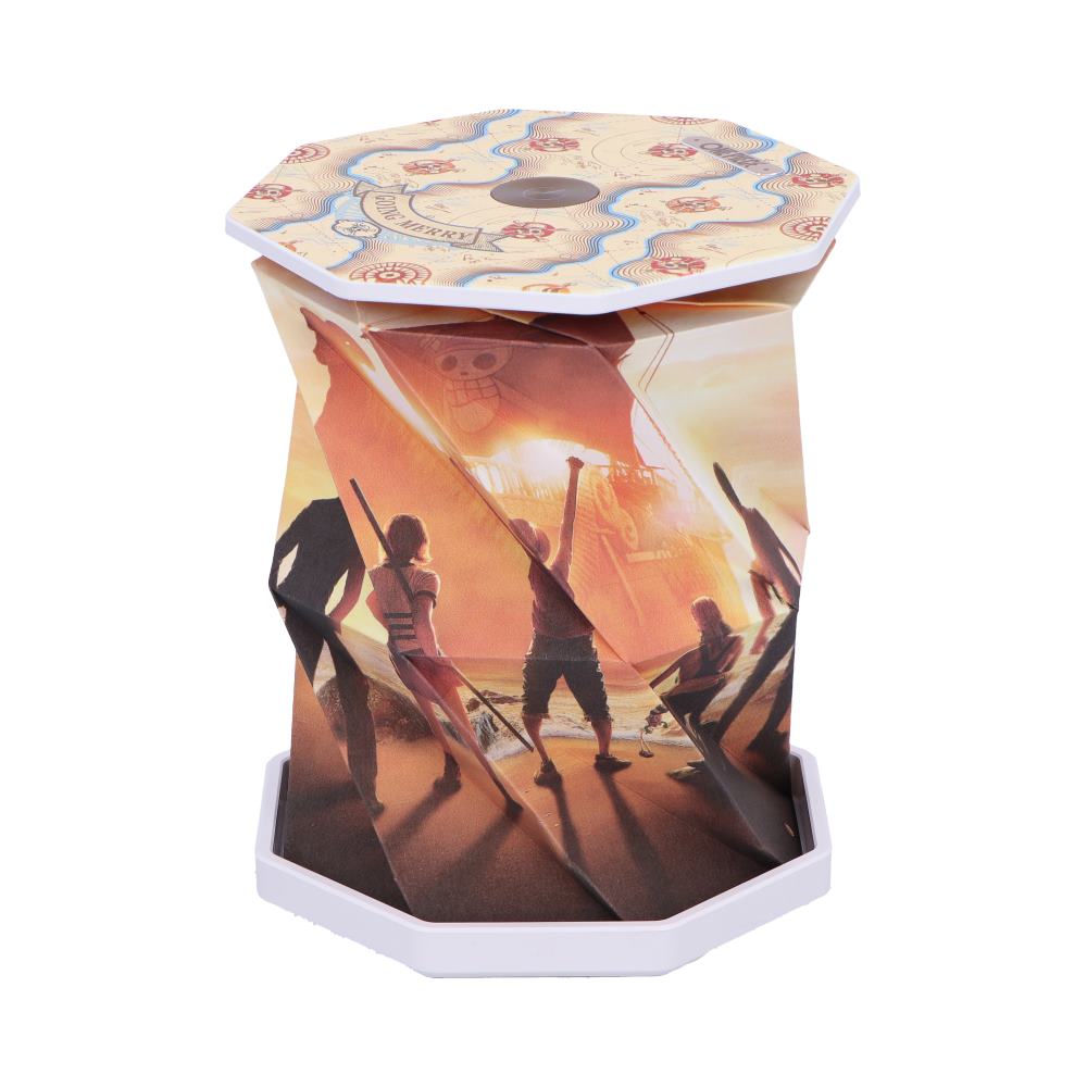 Hexagonal collapsible lamp shows a printed sunset scene of five silhouetted figures raising arms toward a large ship with a glowing sail on the horizon against a white background.