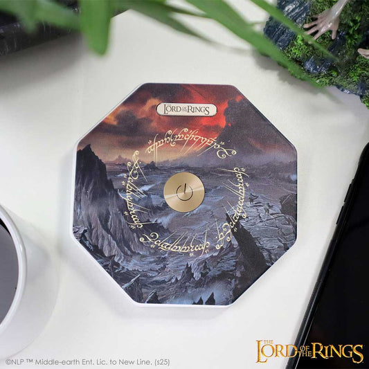 Octagonal Lord of the Rings themed box with a central power button surrounded by Elvish script, sitting on a white desk beside a coffee cup, phone, and plant; text: "The Lord of the Rings" "©NLP TM Middle-earth Ent. Lic. to New Line. (s25)"