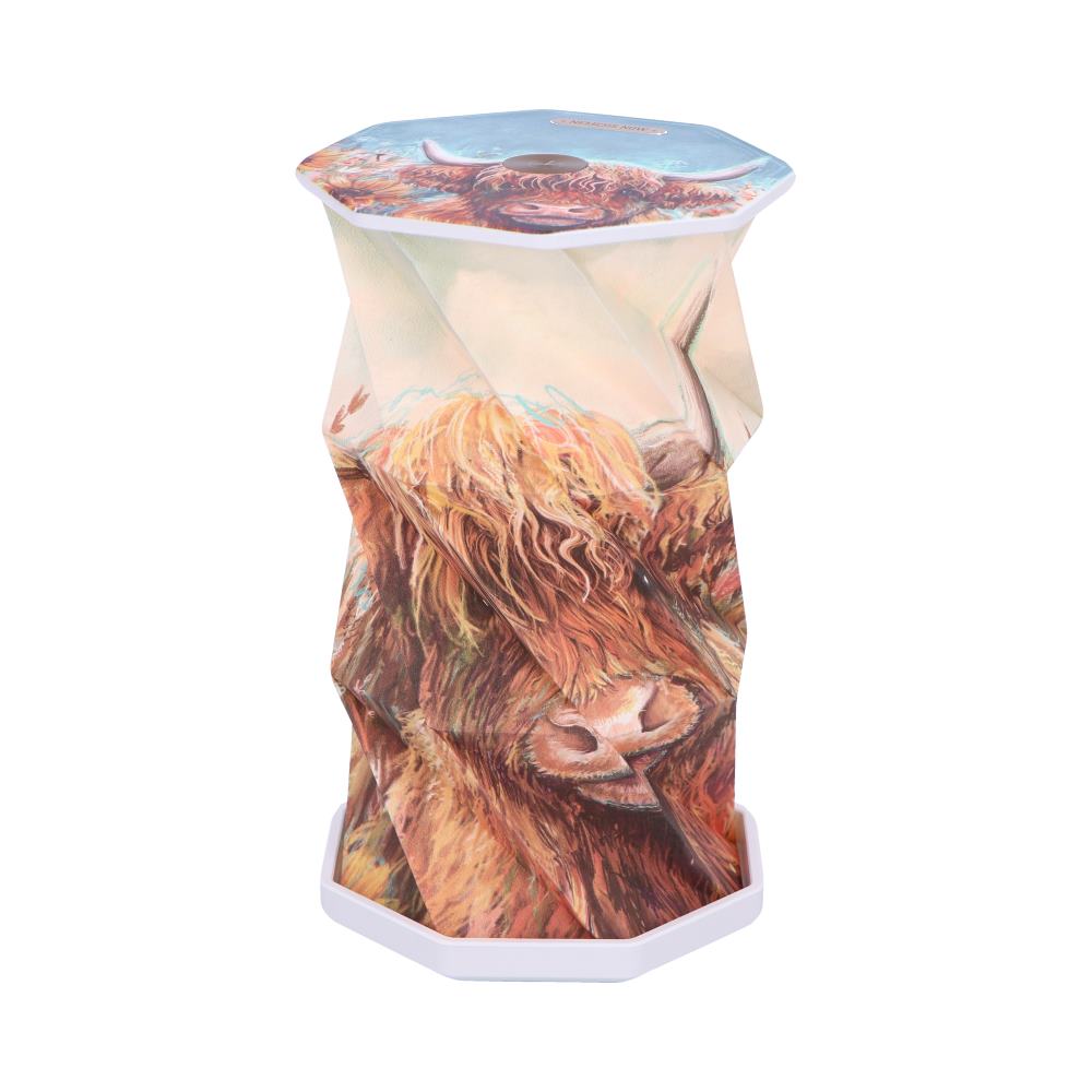 Collapsible octagonal stool stands expanded displaying a colorful painted Highland cow print against a plain white background.