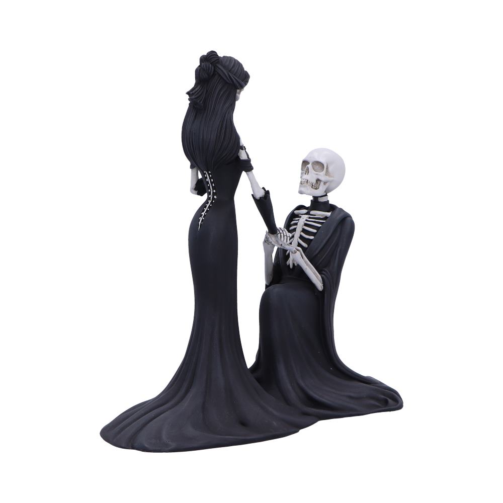 A gothic woman in a fitted long black gown stands as a robed skeleton kneels before her and clasps her hand against a plain white background.
