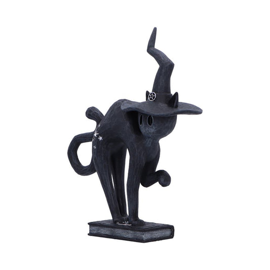 Black cat sculpture stands on a closed book, raising one paw while wearing a crooked witch hat adorned with a pentagram, curling tail and white star accents against background.