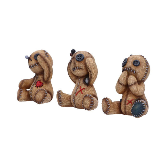 Three small stitched brown rabbit dolls sit in a row on a white background; they have button eyes, visible stitching and patches, one covering its eyes, one covering its ears, and one covering its mouth.