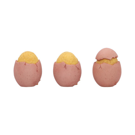 Three pink eggshells reveal fuzzy yellow chick heads, the rightmost shell's top removed, arranged in a row on a plain white background.