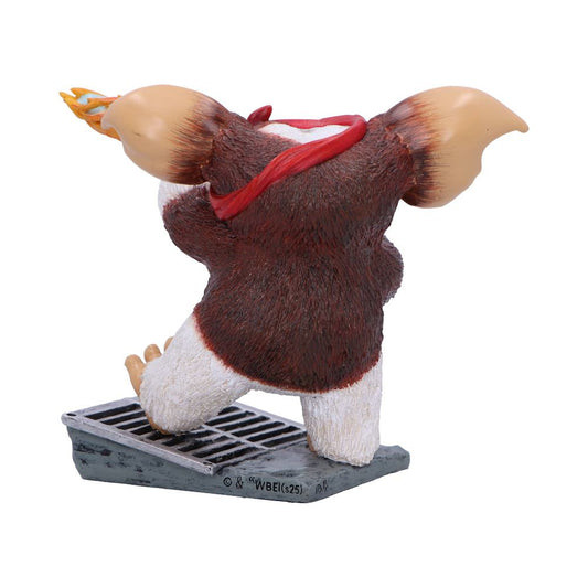 Stuffed creature figurine stepping onto a metal grate with one foot raised, red scarf around neck, large tan ears flared, brown fur and white legs against a white background Text on base: © & ® WBEI (s25)
