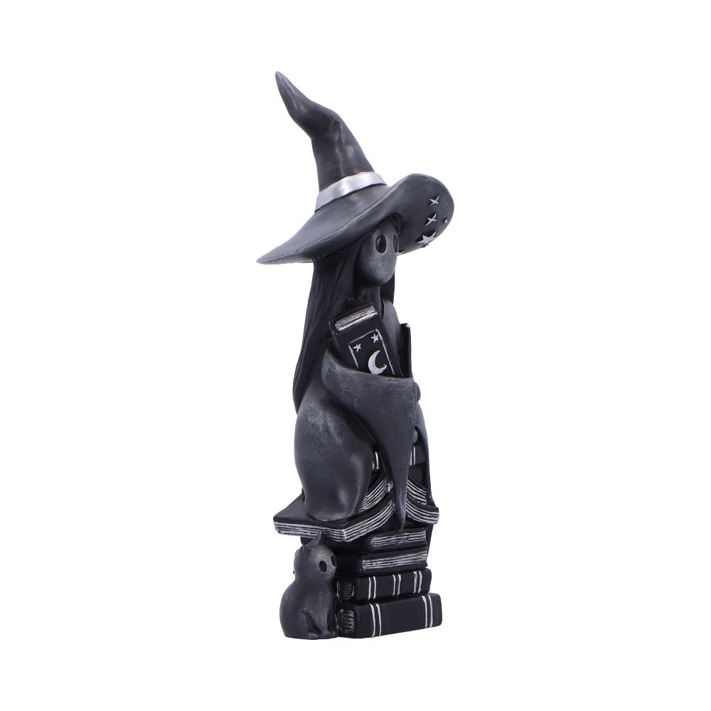 A black stylized cat wearing a pointed witch hat holds a moon-and-stars book while sitting atop a stack of books, small mouse figurine at the base, photographed on white background.