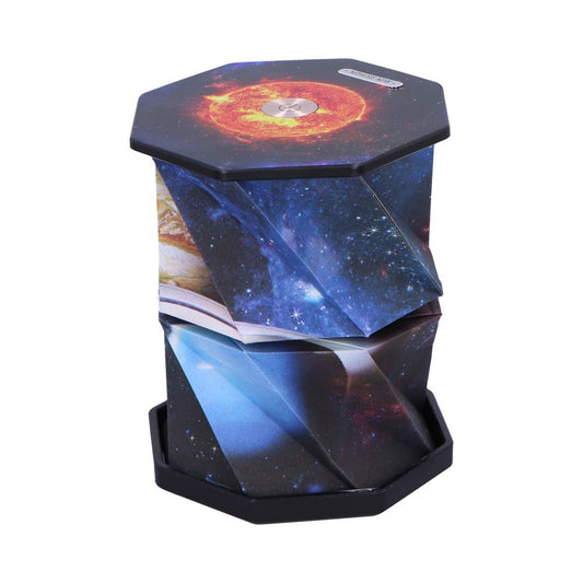 Hexagonal foldable stool featuring galaxy and sun print is collapsed, displaying angular folded panels; photographed on a plain white studio background, no readable text visible.