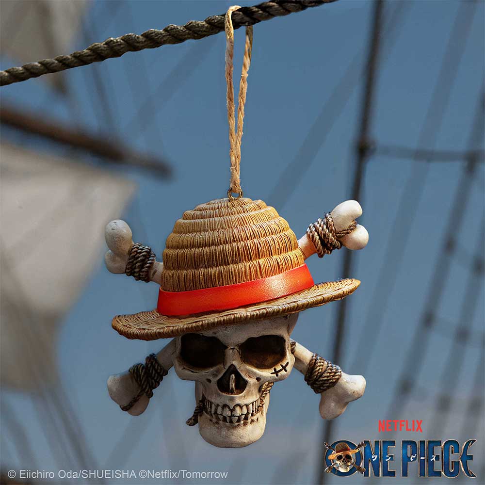 Luffy Jolly Roger ornament hanging from a rope on a blue One Piece background