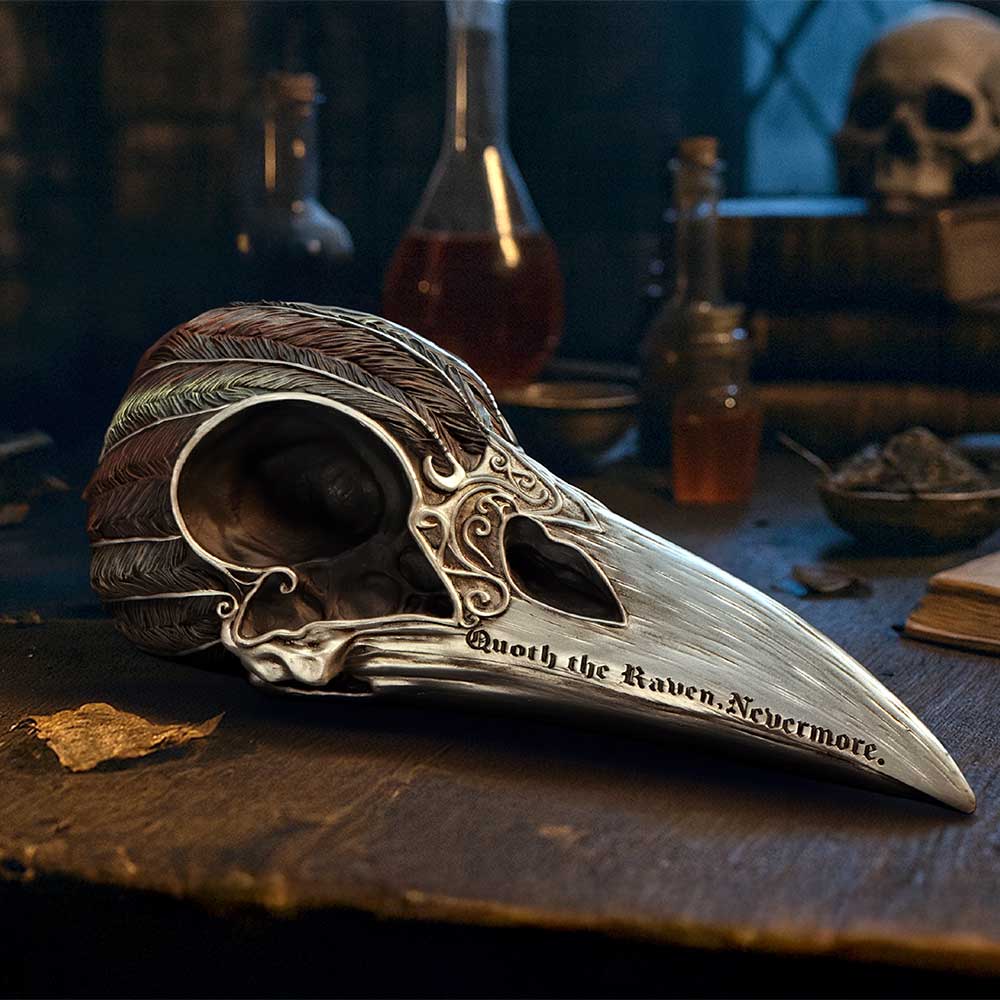 Quoth the Raven Skull Ornament - displayed on a dark desk with its long beak and ornate crown visible