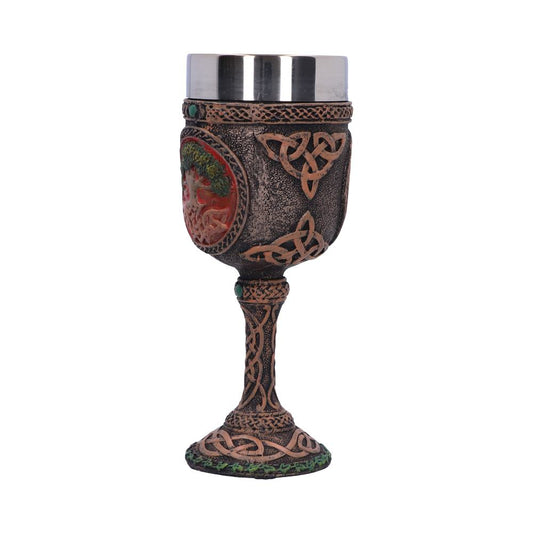 A decorative goblet, featuring Celtic knots and a sculpted tree on its brown, textured body, stands upright against a plain white background. It has a stainless steel cup on top.