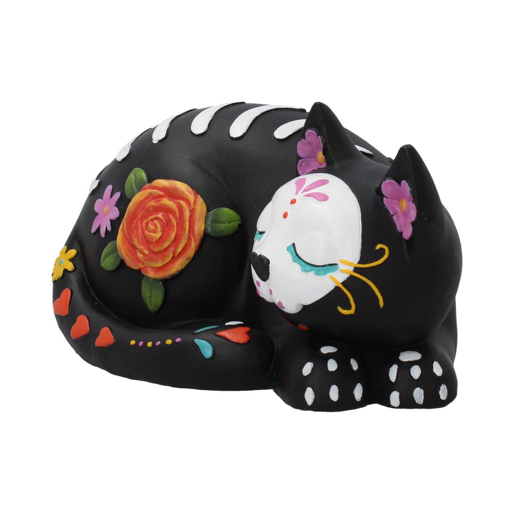 A decorative black sculpture of a sleeping cat features colorful floral patterns and designs, resembling traditional Day of the Dead motifs, against a plain white background.