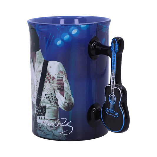 A blue ceramic mug features a portrait of a white-suited performer on stage, with a black guitar-shaped handle. The signature "Elvis Presley" is printed on it.