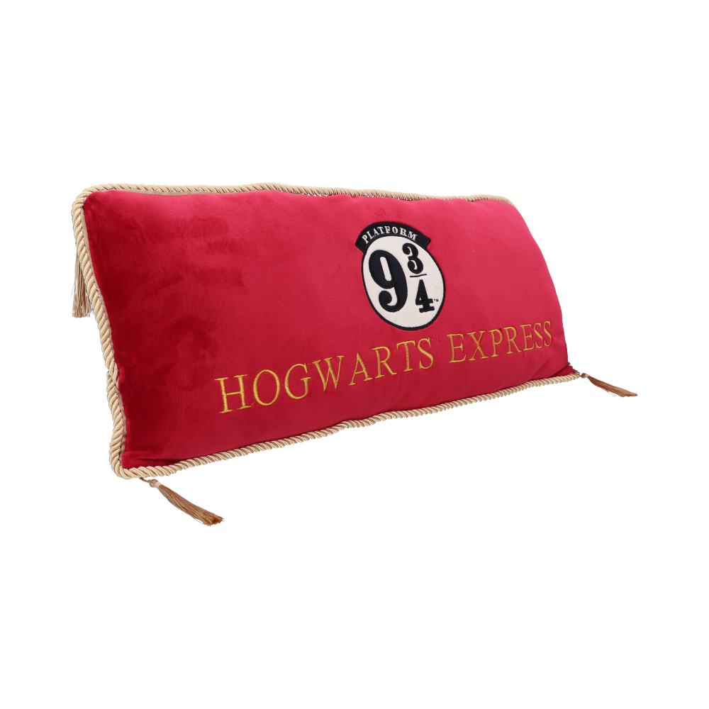 A red rectangular cushion displays the text "PLATFORM 9 ¾" and "HOGWARTS EXPRESS" in gold. It features tassels at the corners and a rope-like border, set against a plain white background.