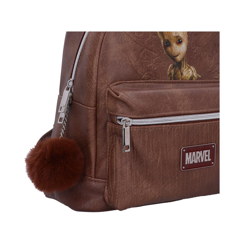 A brown faux-leather backpack, featuring a Groot image and MARVEL logo, sits on a white background. A brown fur pom-pom hangs from a zipper pull.