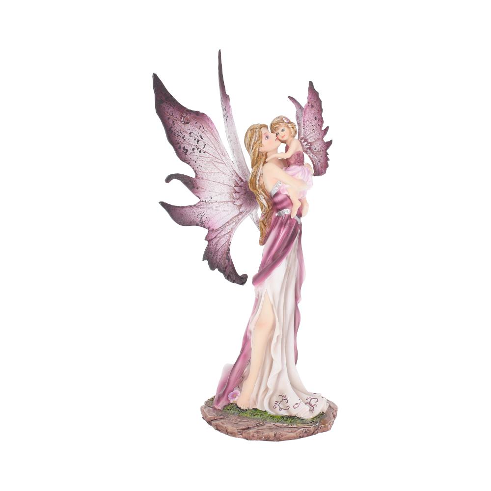 A fairy figurine with pink wings lovingly holds a small child against a white background. Both wear flowing dresses, standing on a round base decorated with grass and flowers.