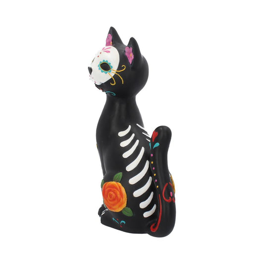 A black cat figurine, sitting upright, features Day of the Dead-style decorations with vibrant floral patterns and skeletal markings, against a plain white background.