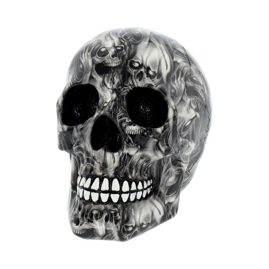 A skull sculpture, covered in a pattern of smaller skulls, is displayed against a plain white background, suggesting a decorative or artistic context.