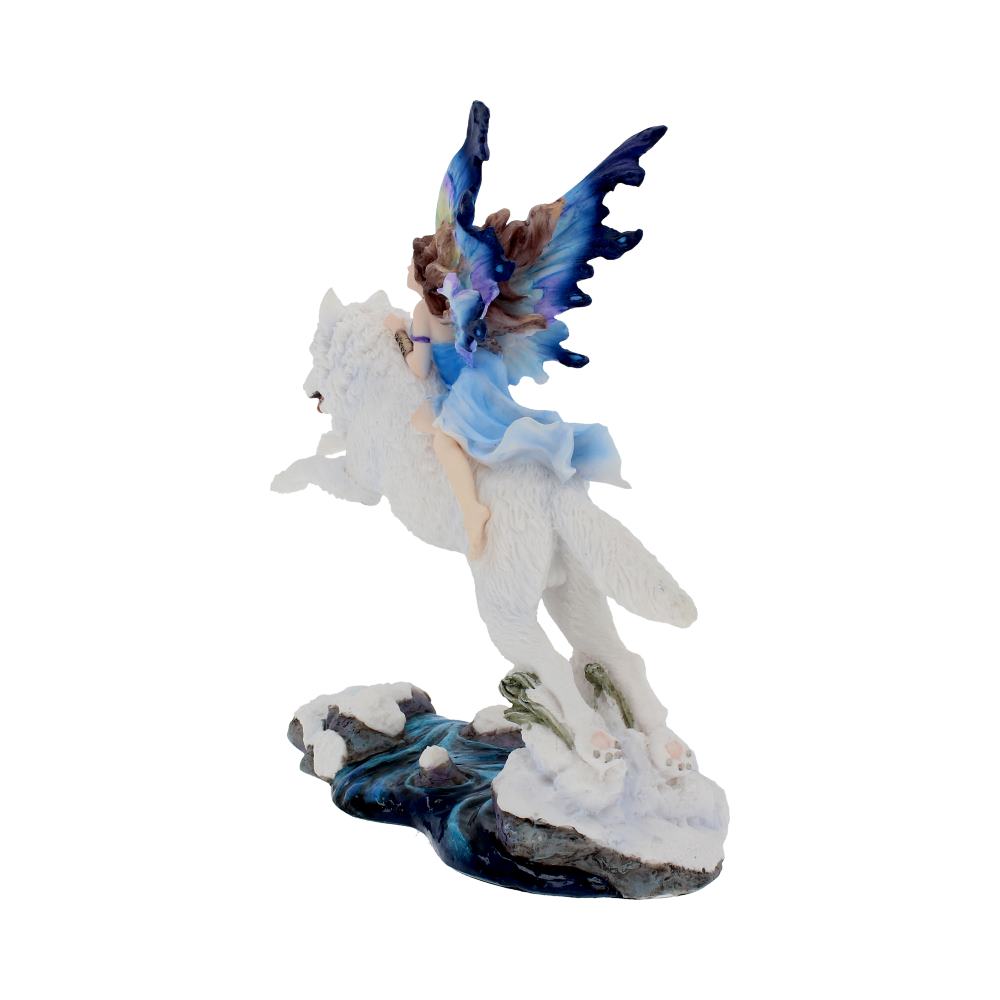 A figurine depicts a fairy with colorful wings riding a white wolf. The wolf stands on a snow-covered base with rocks and flowing water.