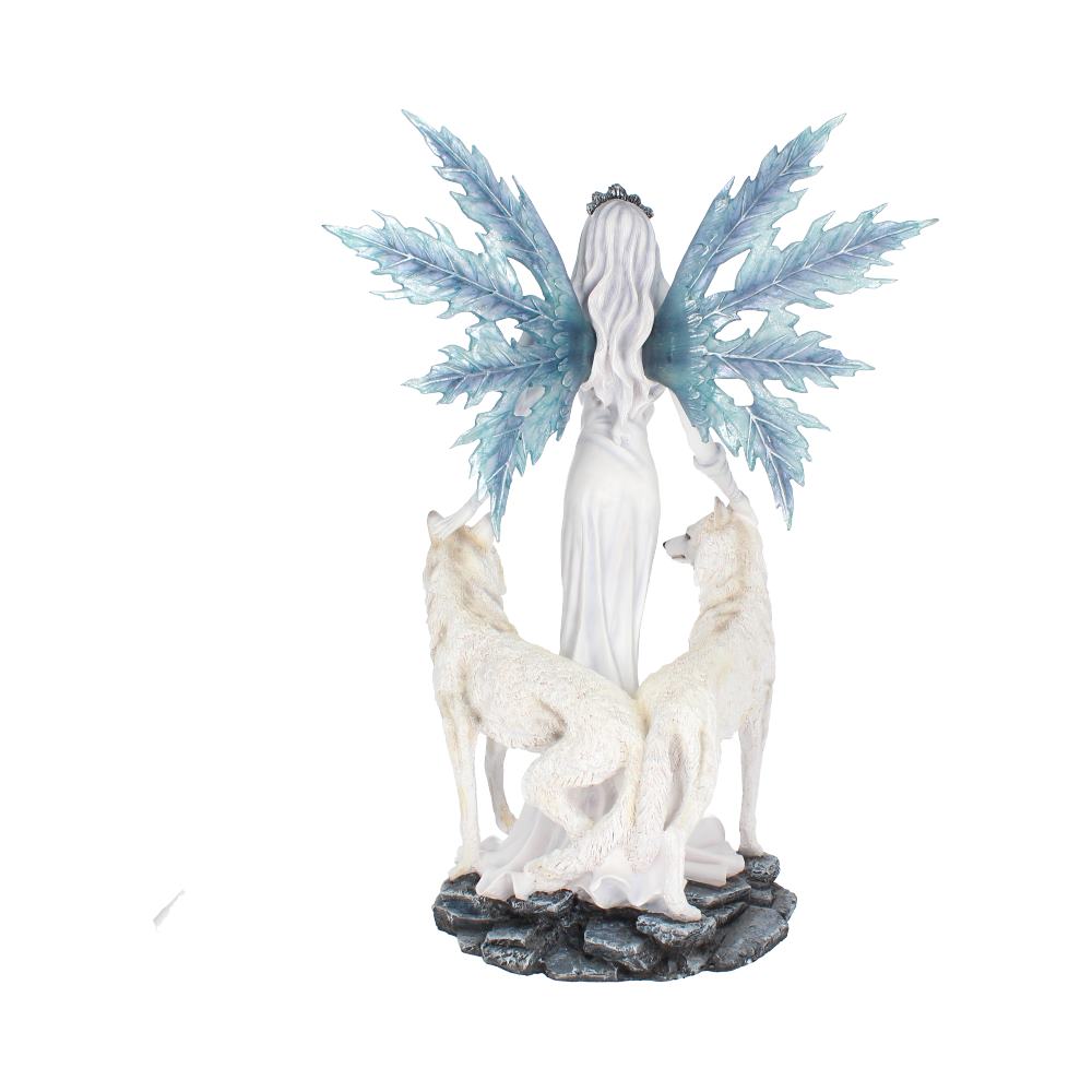 A fairy with intricate blue wings, wearing a white gown, stands with two white wolves beside her on a rocky base, symbolizing an ethereal, mystical setting.